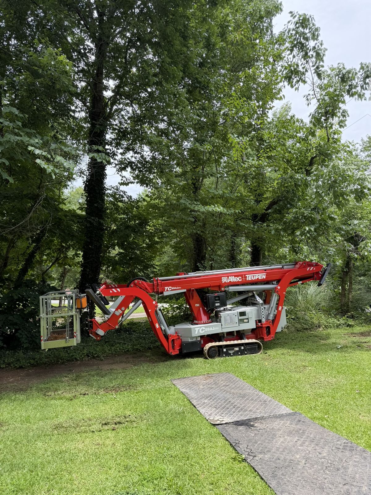 Ground protection mats laid across the lawn under the lift
