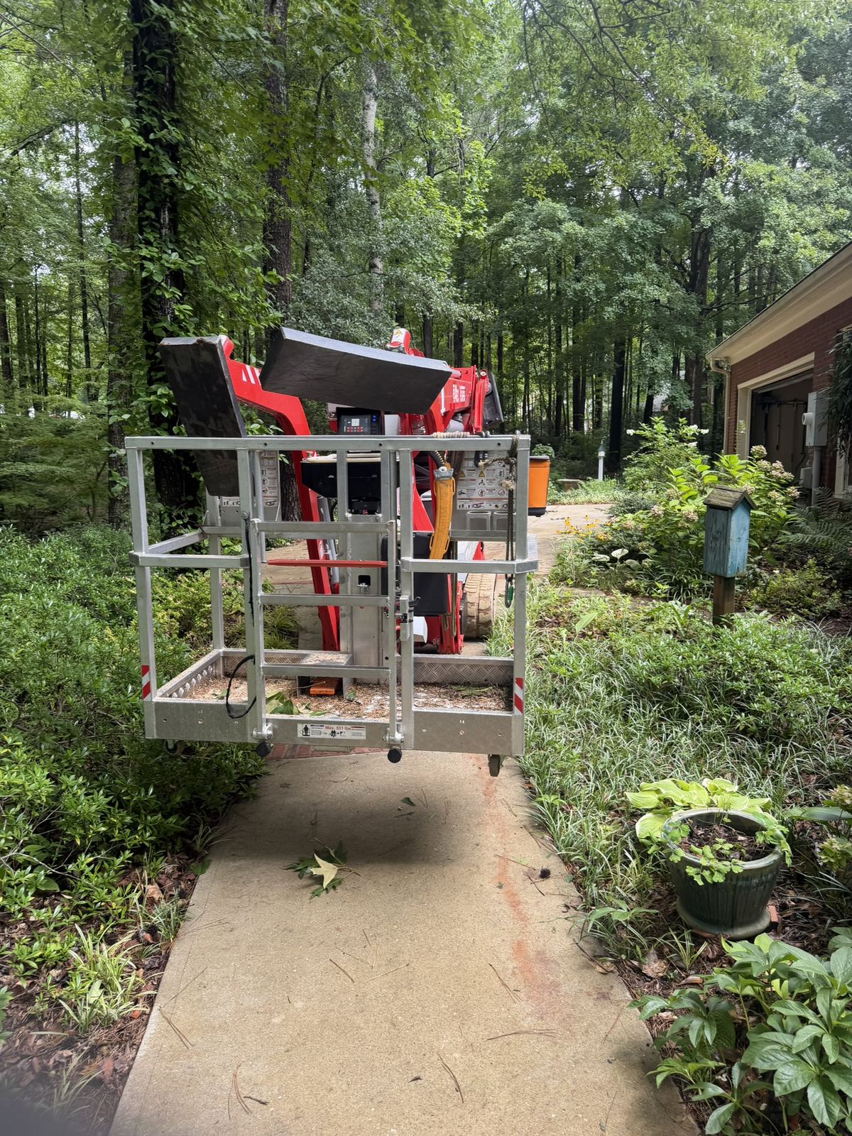 Lift basket working over a planted garden walkway